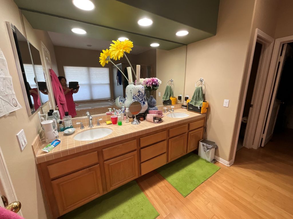 A busy bathroom vanity crowded with bottles and towels.